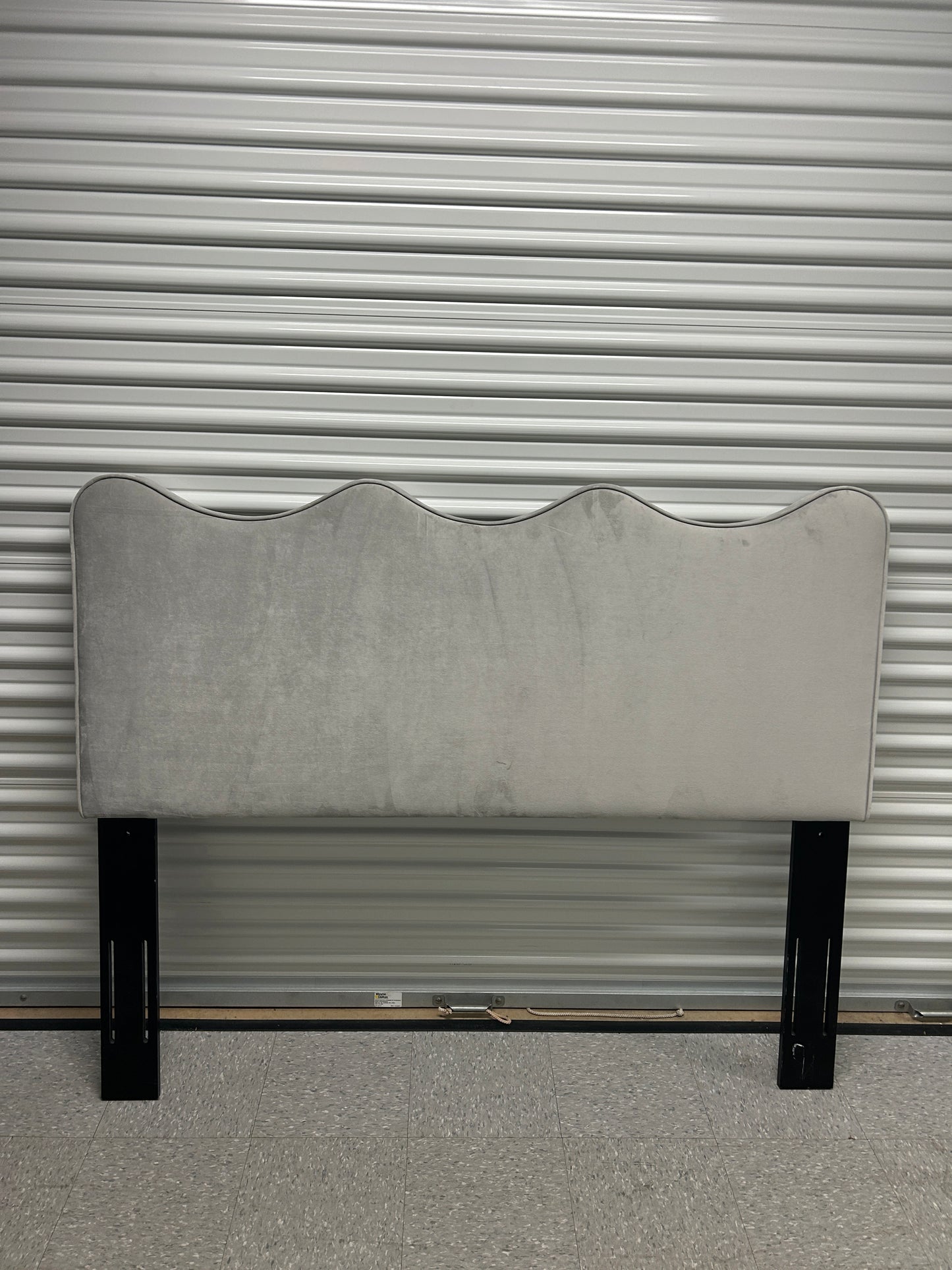 Gray queen velvet headboard with black wooden legs.