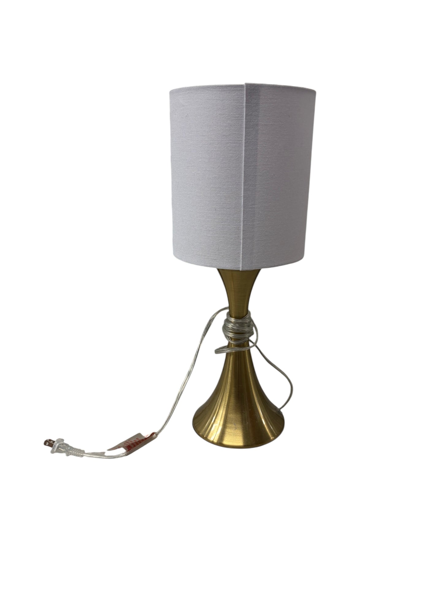 Gold lamp with a white shade and cord.