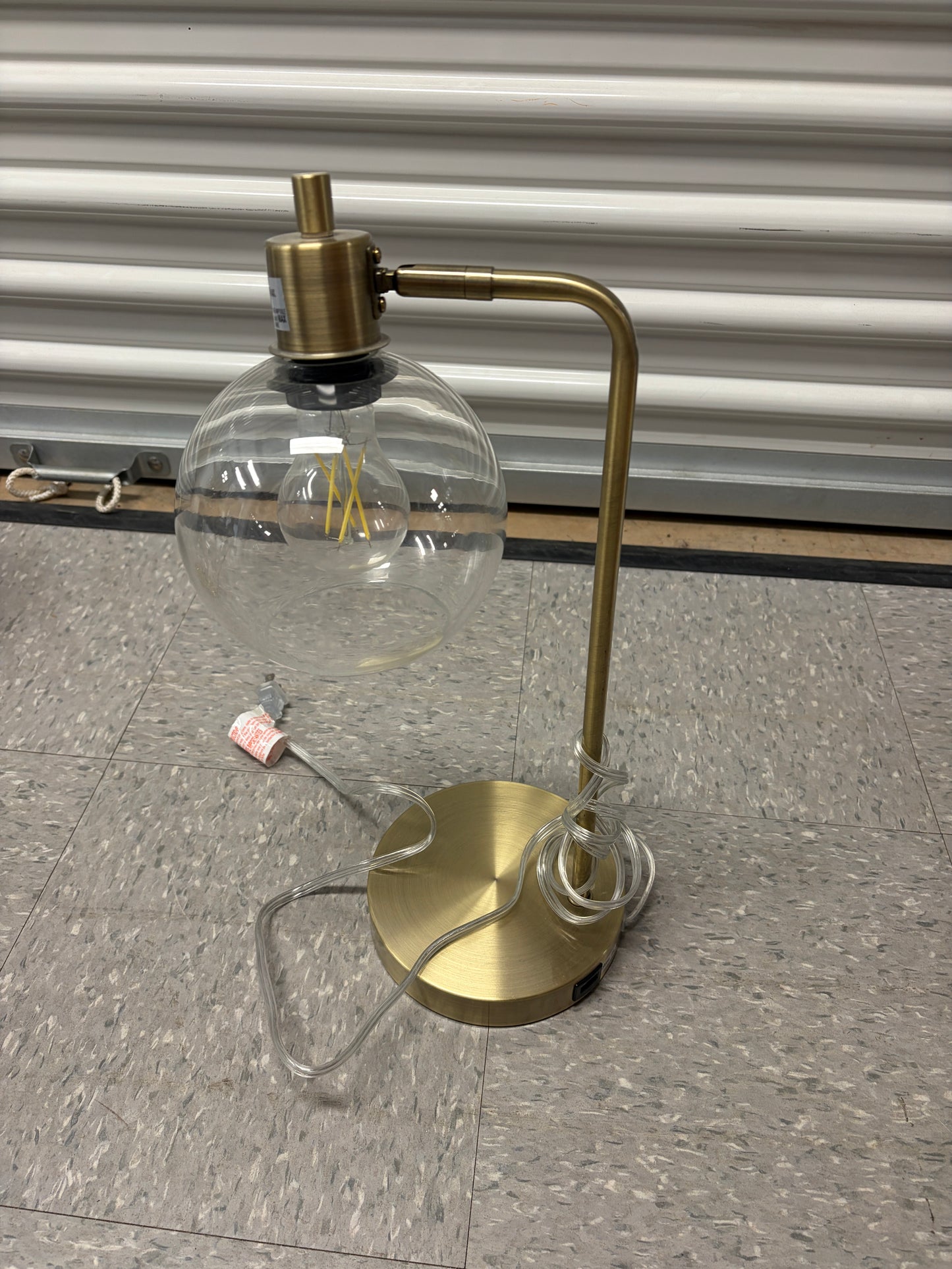 Gold desk lamp with clear glass shade and USB charging port.