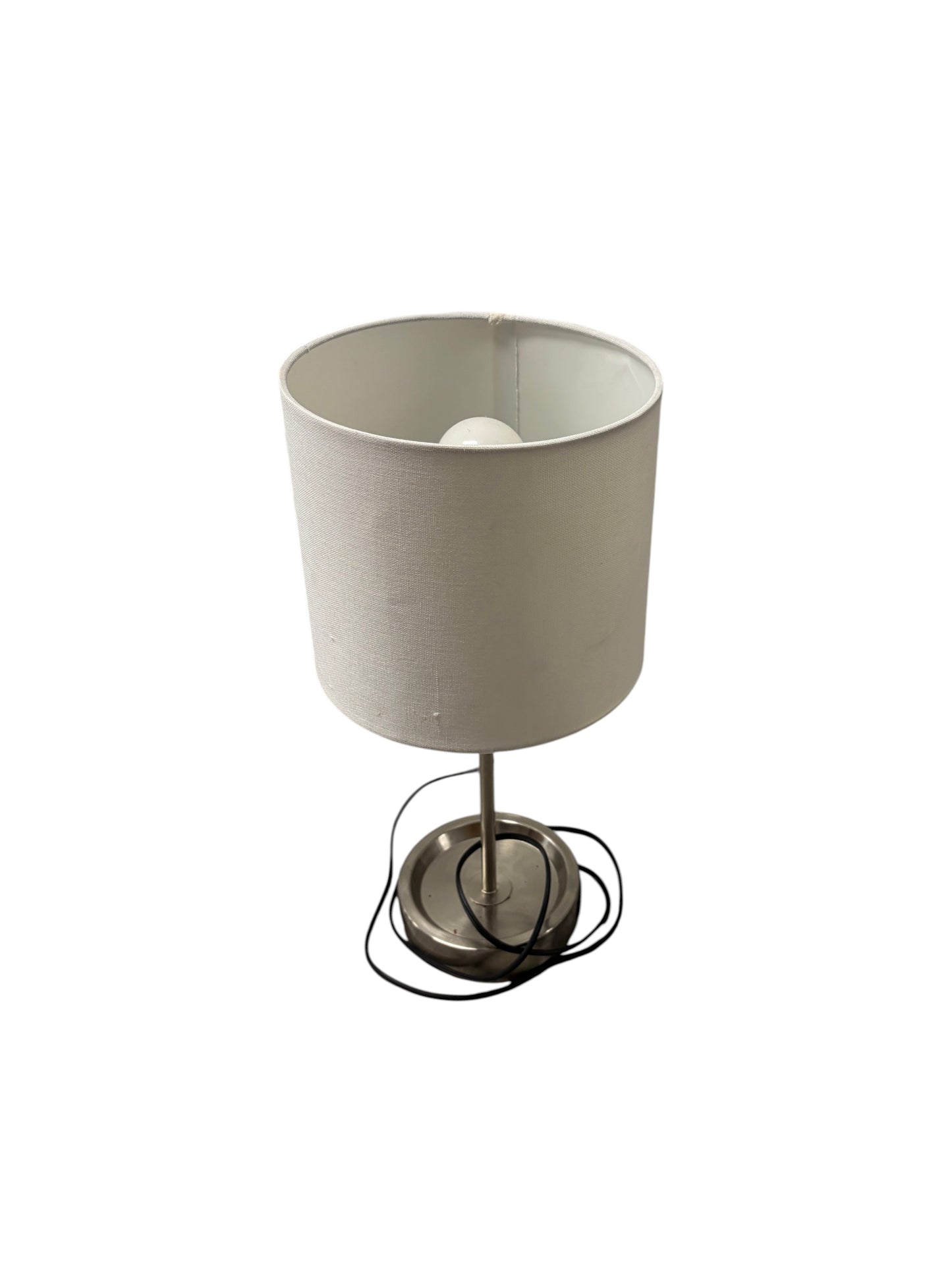 Table lamp with a white shade and silver base with charging outlet.