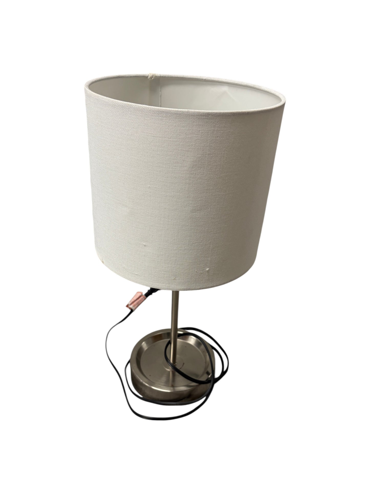 Table lamp with a white shade and silver base with charging outlet.