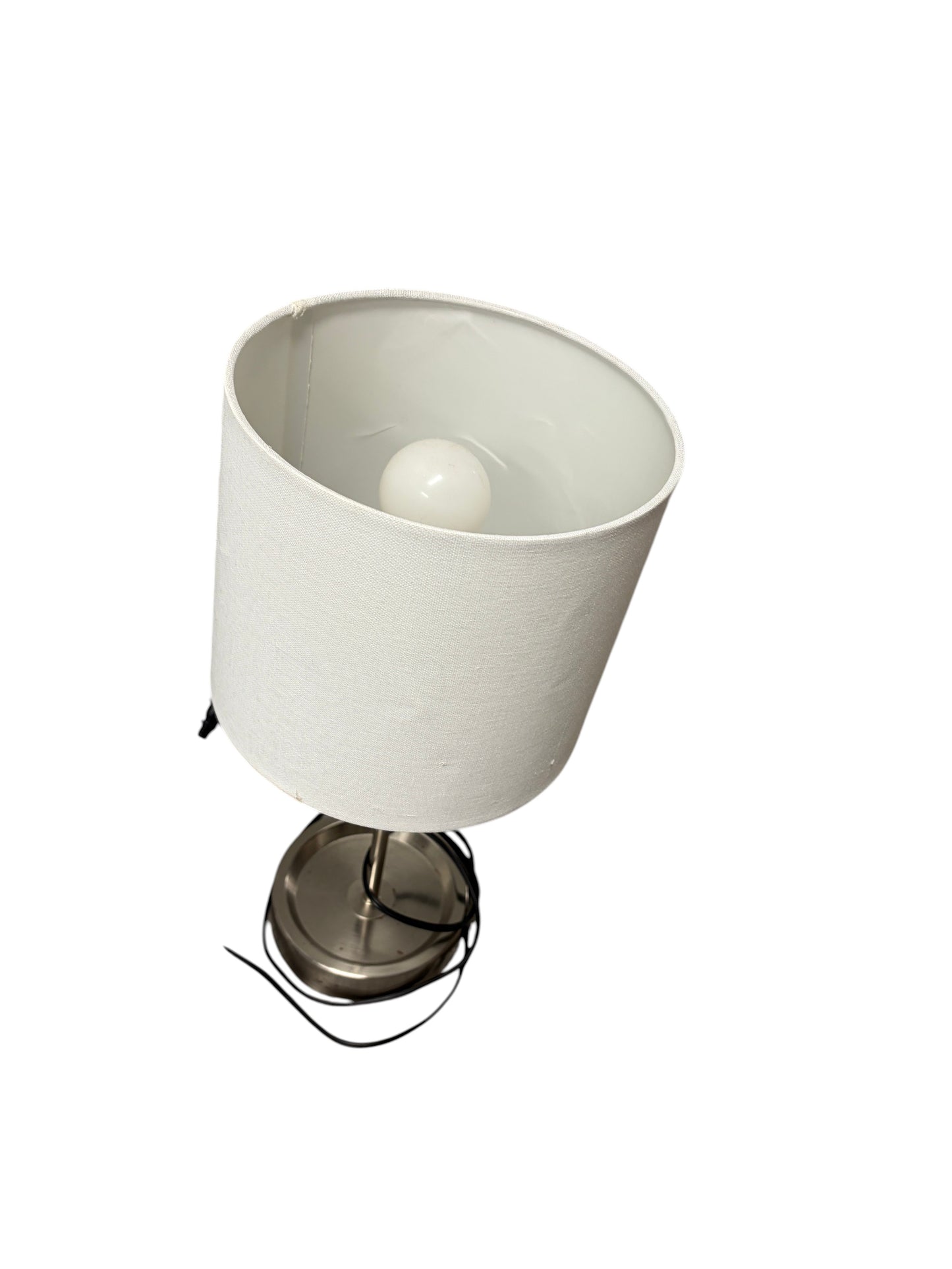 Table lamp with a white shade and silver base with charging outlet.