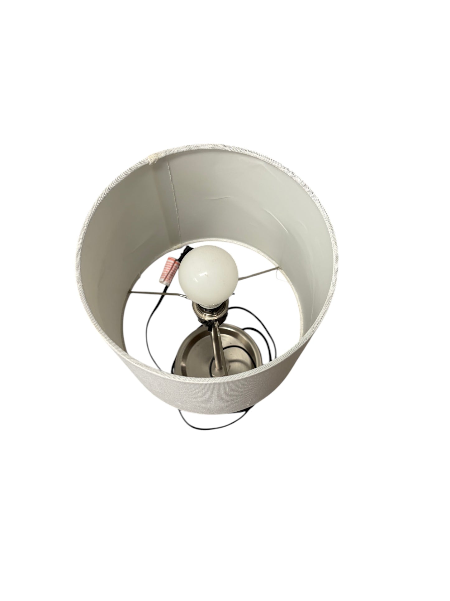 Table lamp with a white shade and silver base with charging outlet.