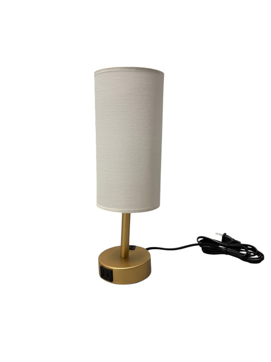Gold lamp with a cream shade and built-in charging ports.