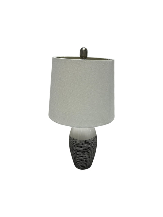 Gray and white table lamp with a textured ceramic base.