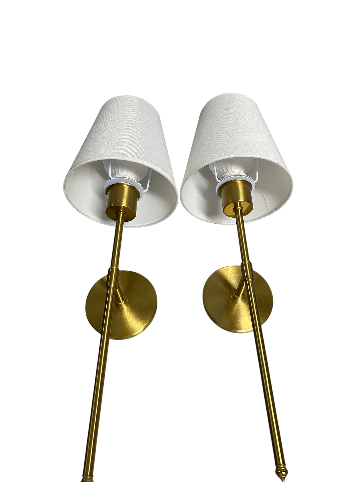 Pair of gold wall sconces with white shades.