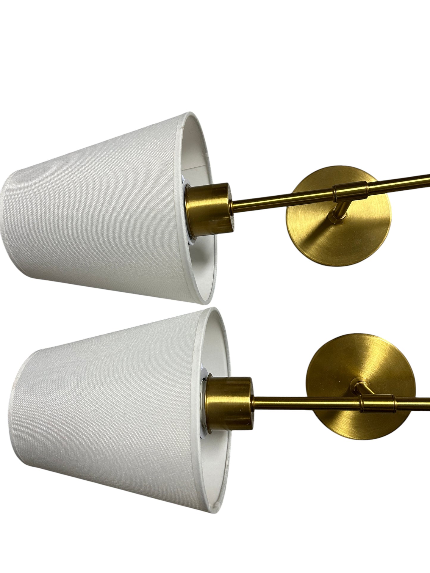 Pair of gold wall sconces with white shades.