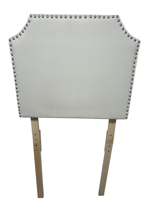 White velvet twin headboard with silver buttons and wooden legs.