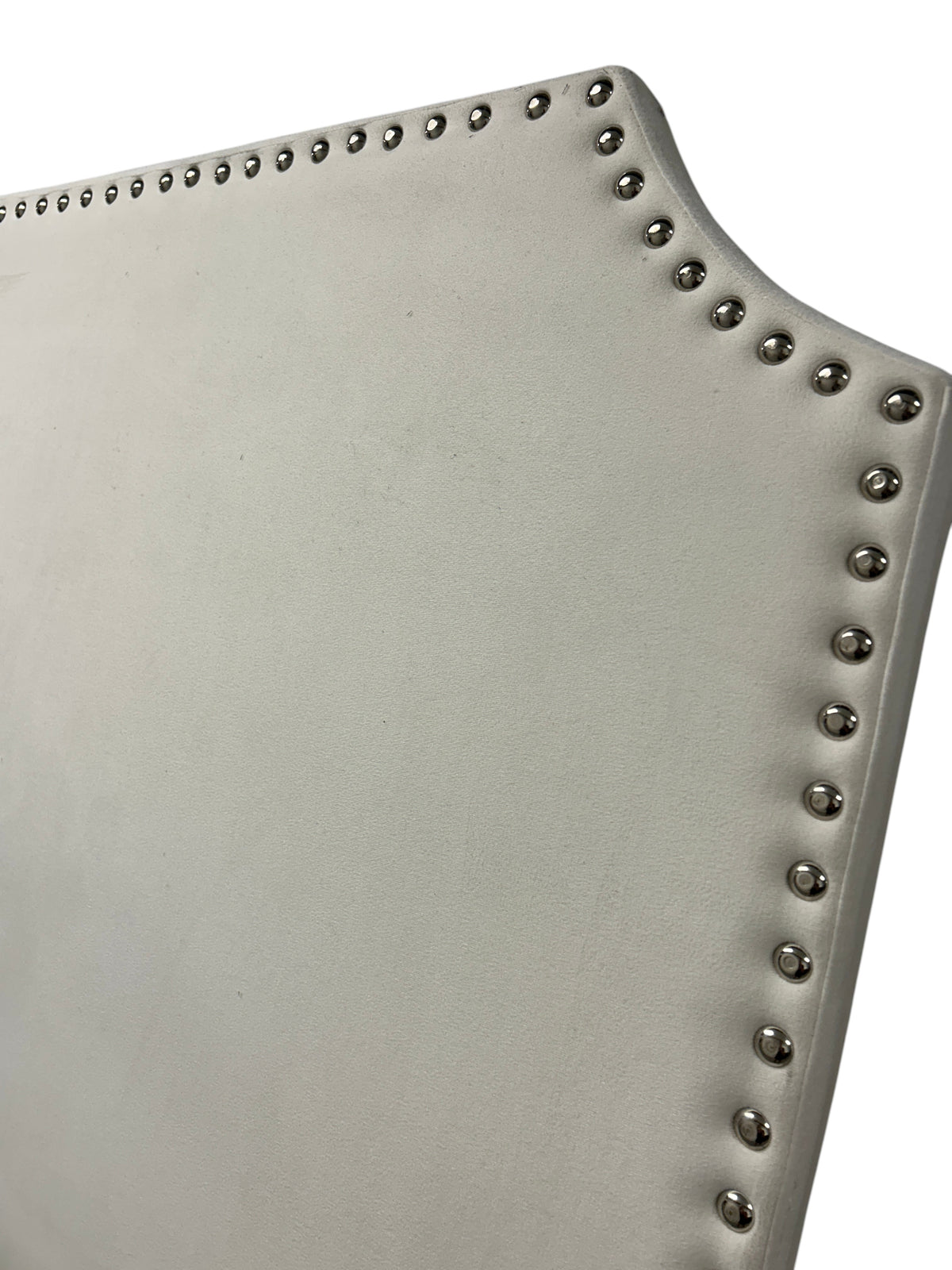 White velvet twin headboard with silver buttons and wooden legs.