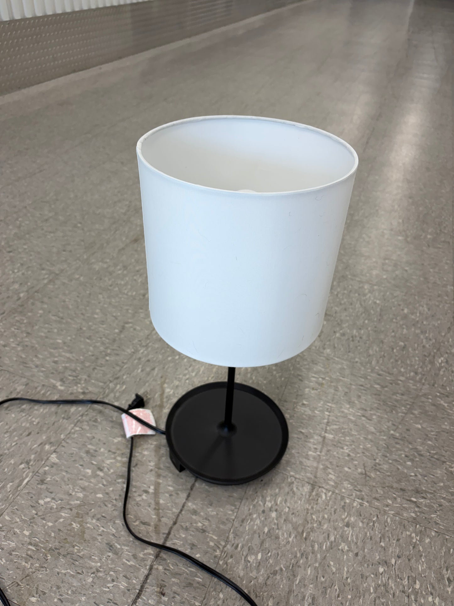 Black table lamp with a charging port.