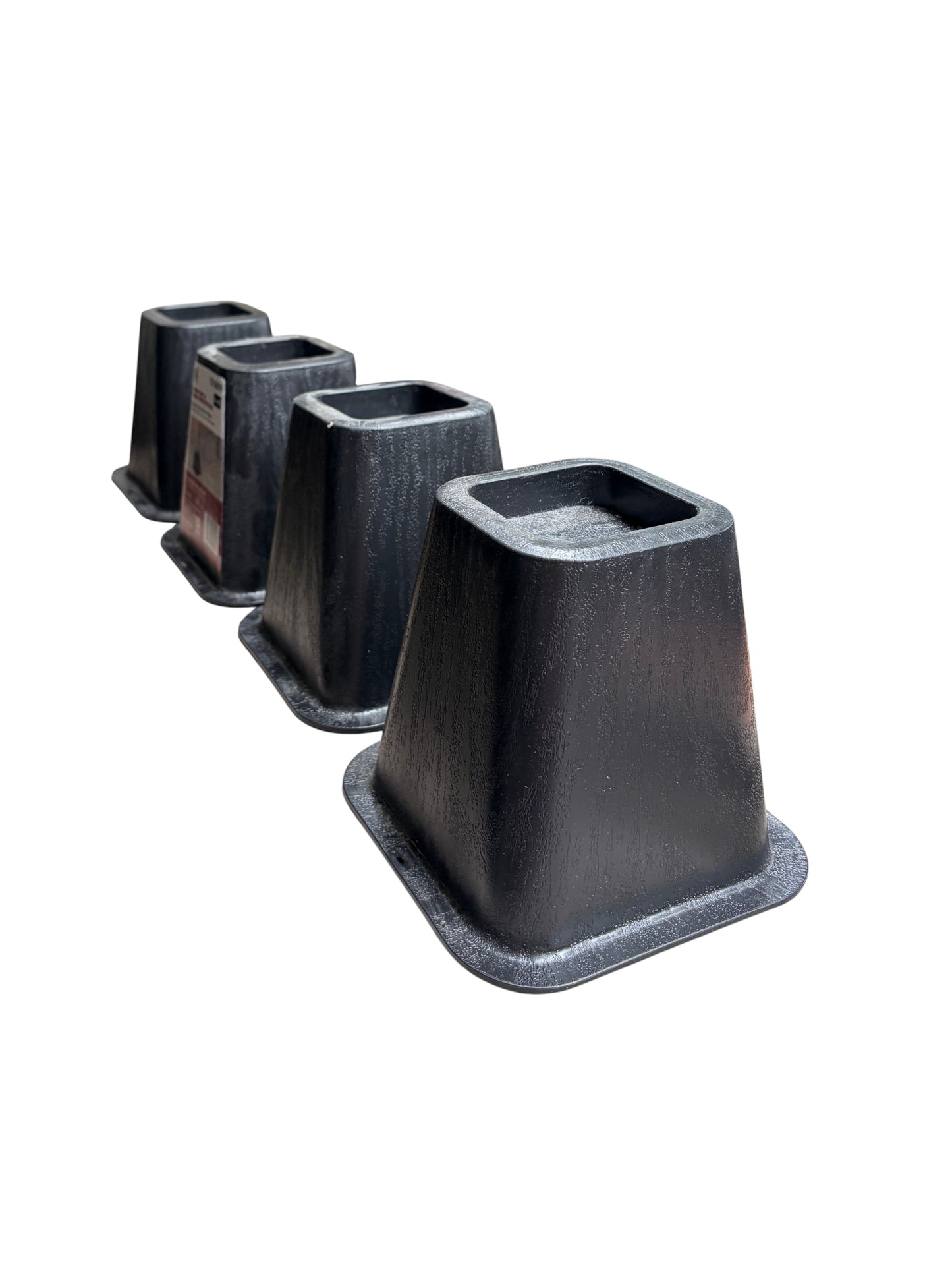 Set of 4 black plastic bed risers.